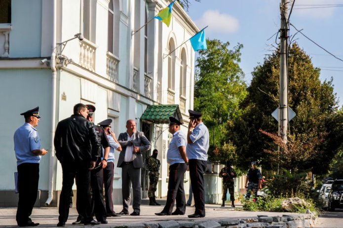 Rusiye küçlüleri Aqmescitte, qırımtatar halqı milliy Meclisiniñ binası yanında tintüv vaqıtında. 2014 sene, ilk küz ayınıñ (sentâbr) 16-sı / Foto: Stanislav Yürçenko, «Krım.Realii» (RFE/RL)