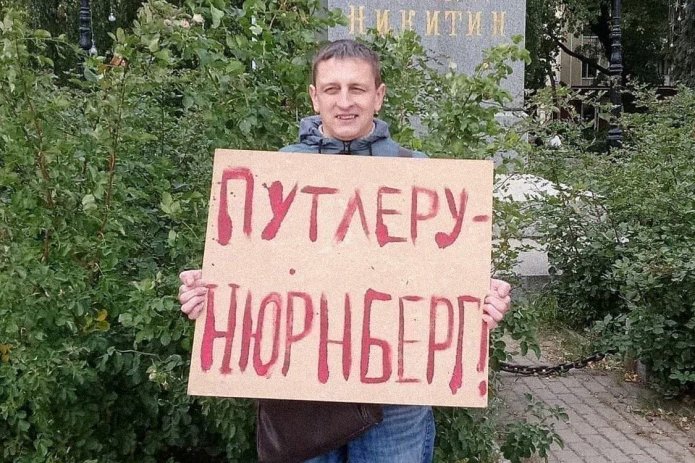 <em>Григорий Северин в одиночном пикете. За этот же плакат в январе 2021 года его <a href="https://umehhimk---mekodxpr-bsccljbcrq-ez.a.run.app/express-news/2021/01/20/voronezhca-arestovali-iz-za-odinochnogo-piketa-v-podderzhku-navalnogo"><u>арестовали</u></a> на пять суток (ч. 8 ст. 20.2 КоАП РФ) / Фото: Свободные Люди Воронежа</em>